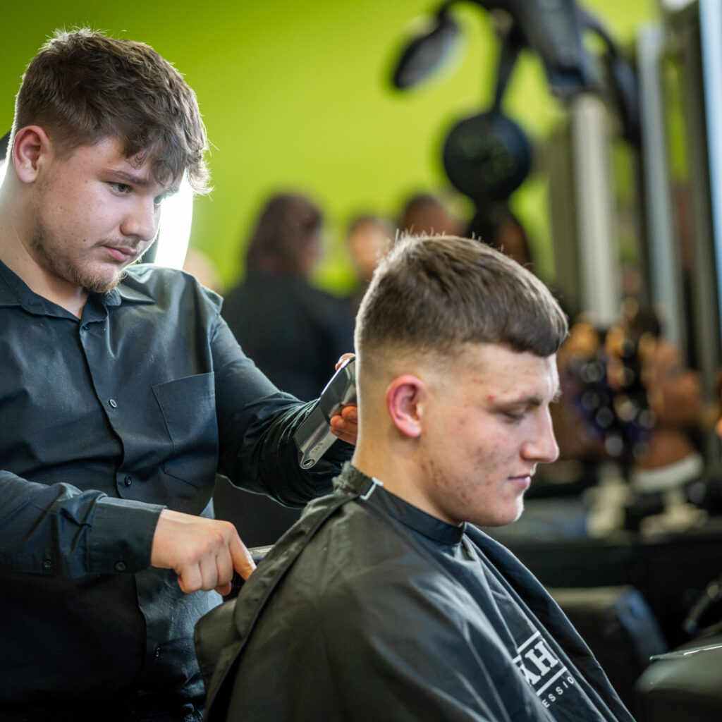 A student cutting a client's hair in the salon