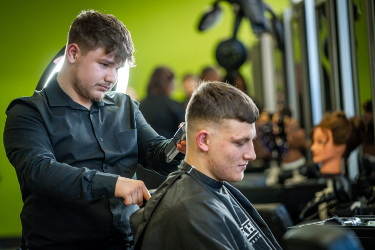 A student cutting a client's hair in the salon