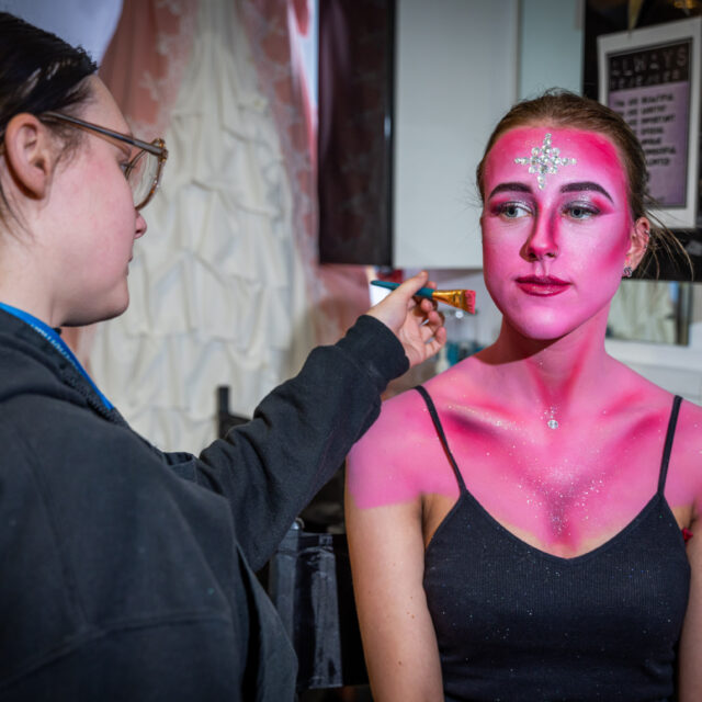 A media make up student applying theatrical make up