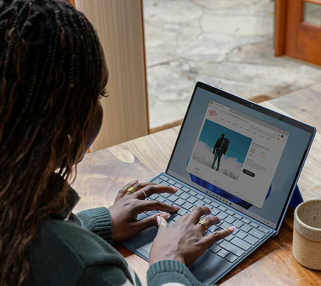 Someone sat at a desk working on a laptop at home